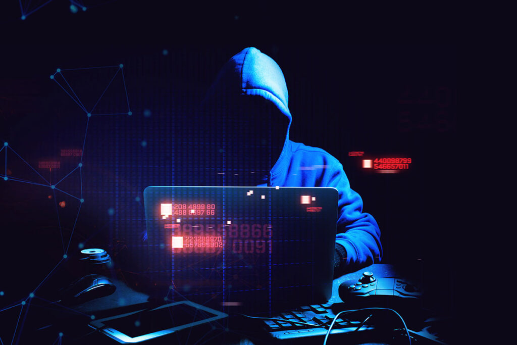 hacker in a hoodie in front of computer